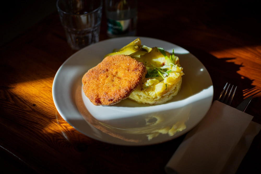 Holandský řízek s bramborovou kaší na talíři – profesionální food fotografie pro restauraci U Dvou pupků.